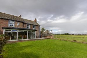 a house with a large lawn in front of it at EASTCOTE FARM - Spacious 5-Bed Home with Views, Garden & Playroom in Silloth