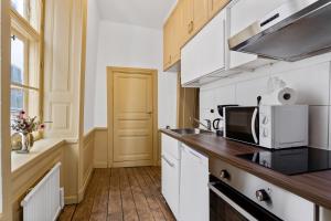 ストックホルムにあるCharming Apartment in Old Townの白いキャビネットと電子レンジを備えたキッチン
