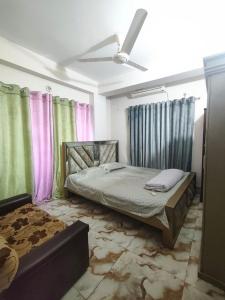 a bedroom with a bed and a ceiling fan at Lovely 2 Bed apartment in Nikunja 2, 5 Mins drive from Dhaka ShahJalal Airport in Dhaka