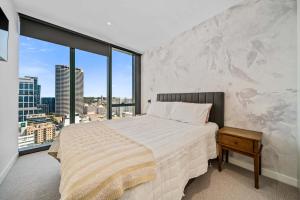 a bedroom with a bed and a large window at Luxury Perth CBD Apartment with Pool & Gym in Perth