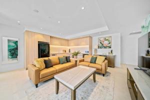 a living room with two couches and a table at Luxury Perth CBD Apartment with Pool & Gym in Perth +59 photos