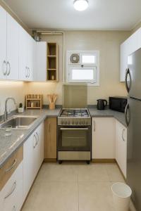 a kitchen with white cabinets and a stove top oven at Madinty Stylish Stay in B6 in Madinaty