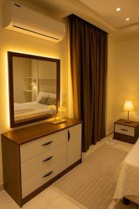 a bedroom with a large mirror on a dresser at Madinty Stylish Stay in B6 in Madinaty