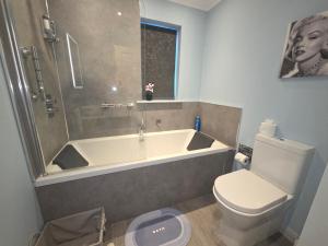 ein Badezimmer mit Badewanne und Toilette in der Unterkunft Room on the River in Cruden Bay + 28 Fotos
