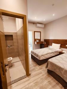 カイロにあるSwiss Tahrir downtown hotelのホテルルーム ベッド2台、シャワー付