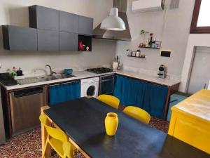 a kitchen with a black table and yellow chairs at Residenza La Terrazza in Arezzo