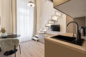 una cocina con fregadero y una escalera en una habitación en Wesselenyi 33 - Stylish Apartments, Best Location by BQA, en Budapest
