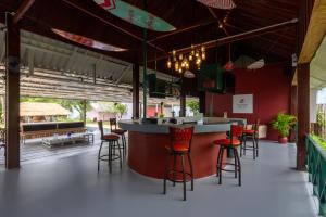a bar in a restaurant with red walls and stools at Slumber Resort Koh Chang in Ko Chang