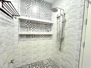 a bathroom with a shower with a black and white tile wall at Merit Courtyard Suvarnabhumi House in Lat Krabang +115 photos