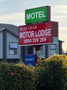 a sign for a motor lodge in front of a house at Motel Homestead in Auckland