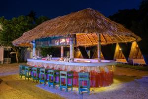 a bar with chairs and a straw umbrella at Slumber Resort Koh Chang in Ko Chang