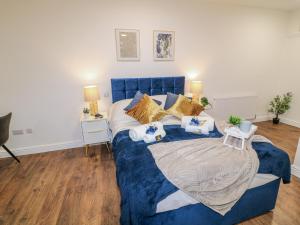 a bedroom with a blue bed with pillows at Two in Peterborough