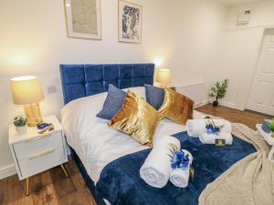 a bedroom with a blue bed with towels on it at Two in Peterborough