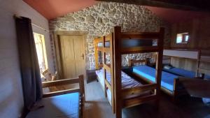 two bunk beds in a room with a stone wall at Gîte de la Ferme des Bourettes in Haute-Rivoire