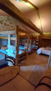 a room with two beds and a desk in a room at Gîte de la Ferme des Bourettes in Haute-Rivoire