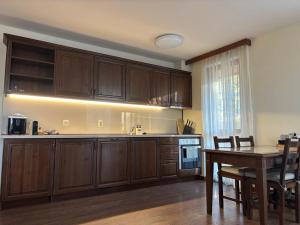 a kitchen with wooden cabinets and a wooden table at Emily Pirin Golf in Razlog