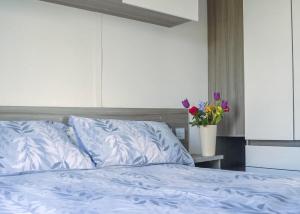 a bed with blue sheets and a vase of flowers at Anchor Park in Happisburgh