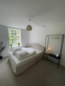 Un dormitorio blanco con una cama y una ventana. en Valby family apartment, en Copenhague