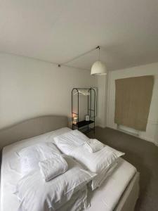 Una cama blanca con dos almohadas encima en una habitación. en Valby family apartment, en Copenhague