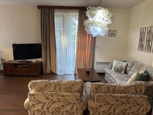 a living room with a couch and a tv at Emily Pirin Golf in Razlog