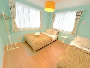 una camera da letto con due letti, un tavolo e finestre di THE FEEL ONNA 2 / Vacation STAY 18794 a Onna