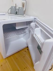 an empty refrigerator with its door open in a kitchen at Sunflower 民泊 in Tokyo +35 photos