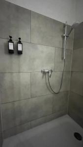 Un baño con ducha con dos monitores en la pared. en Bahnhof Suites I 3 Zimmer I Komfort mit Aussicht und 3 Balkonen, en Bad Bevensen
