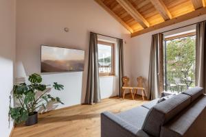 a living room with a couch and a large window at Schwaigermühle Apartments in Kirchberg in Tirol