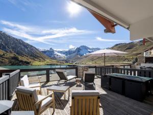 a deck with chairs and tables and a view of mountains at Appartement au centre de Tignes avec terrasse et Wifi - FR-1-641-82 in Tignes