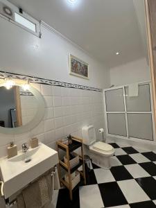 a bathroom with a sink and a toilet and a mirror at Residência Mendonça in Faial