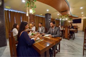 a group of people sitting at a table in a restaurant at FabHotel Red Rose - Nr IIT Guwahati in Amingaon