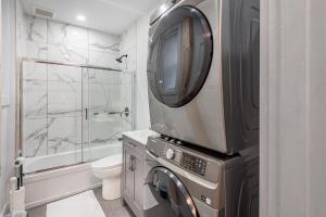 a small bathroom with a washer and dryer in it at 4BR Penthouse - Parking - 2 King & 2 Queen in Montréal +76 photos