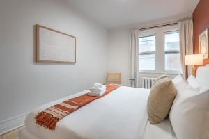 a white bed in a room with a window at 4BR Penthouse - Parking - 2 King & 2 Queen in Montréal