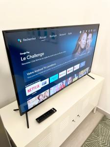 a television on a white stand with a website on it at Cocon tout confort à 25 min de Paris in Sevran
