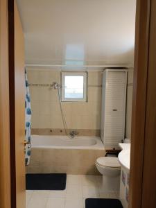 a bathroom with a tub and a toilet and a sink at Maria Cozy Getaway in Glyfada in Athens