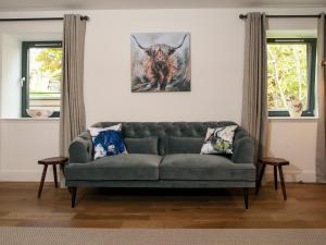 a living room with a couch and a picture of a bull at Strathspey Lodge in Duthil +22 photos