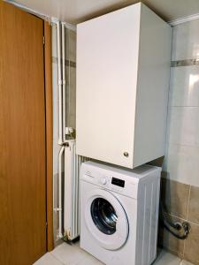 a washing machine with a cabinet on top of it at Maria Cozy Getaway in Glyfada in Athens