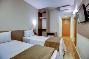 a hotel room with two beds and a flat screen tv at Blue Tree Towers Sorriso in Sorriso