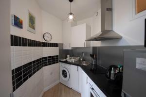 a kitchen with a sink and a washing machine at Studio de charme in Pantin