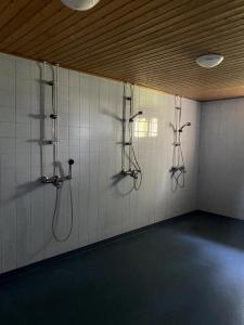 een badkamer met drie douchesystemen aan de muur bij Viihtyisä esteetön saunallinen asunto entisellä paloasemalla in Sievi