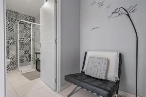 a black chair in a white room with a lamp at Les loges de Pérelle in Chozeau +35 photos