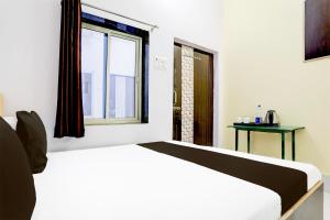 a white bed in a room with a window at Indian Hotel in Bareilly