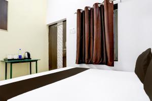 a bedroom with a bed and a window with curtains at Indian Hotel in Bareilly