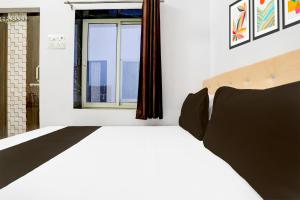 a bedroom with a white bed and a window at Indian Hotel in Bareilly