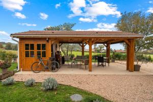 a wooden gazebo with a bike parked in it at Les loges de Pérelle in Chozeau