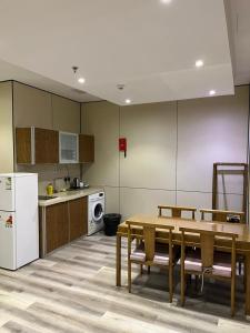 une cuisine avec une table et un réfrigérateur blanc dans l'établissement Dar Hashim Al Nuzha Serviced Apartments - Economic, à Riyad