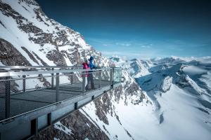 2 personnes debout sur une plate-forme d'observation au sommet d'une montagne dans l'établissement Carpe Solem Kaprun 4 star superior Hotel by ALPS RESORTS, à Kaprun