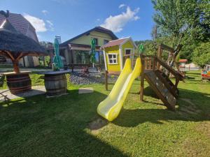 a playground with a yellow slide in the grass at Farm Stay Šolinc in Laško