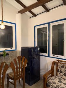 a kitchen with a black refrigerator and two windows at Taco Super Place in Unawatuna +13 photos
