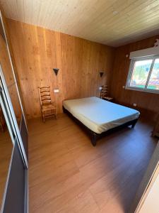 クソンリュプト・ロンジュメールにあるchalet pour amoureux à Gérardmerのベッドと椅子のある寝室